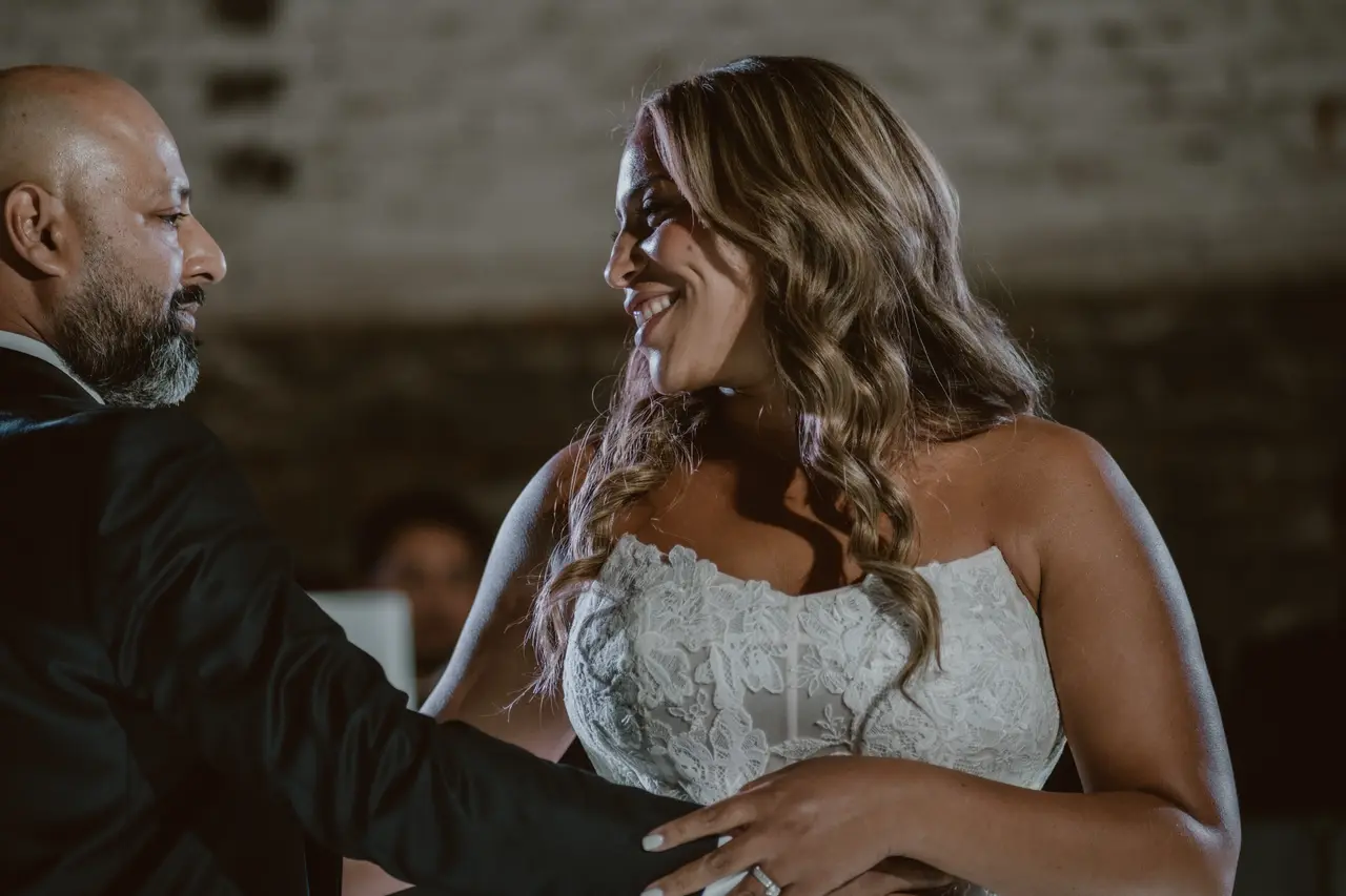 La novia se ríe con la cara pegada a la de él mientras bailan