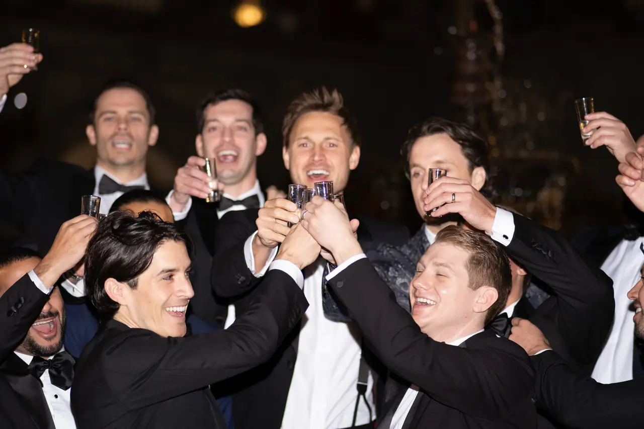 Los amigos del novio brindan con las copas en alto