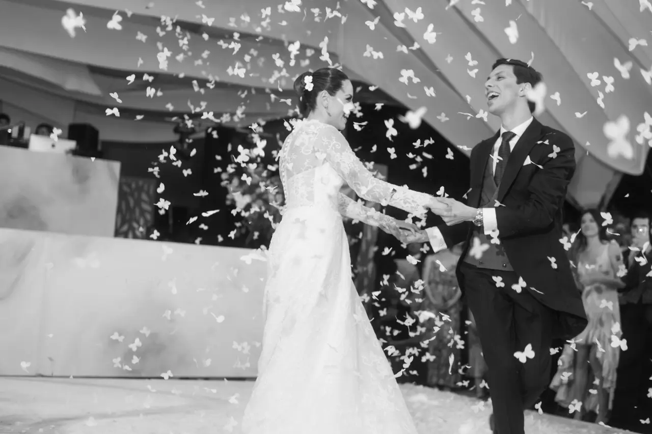Los novios bailan mientras el confeti blanco les cae encima