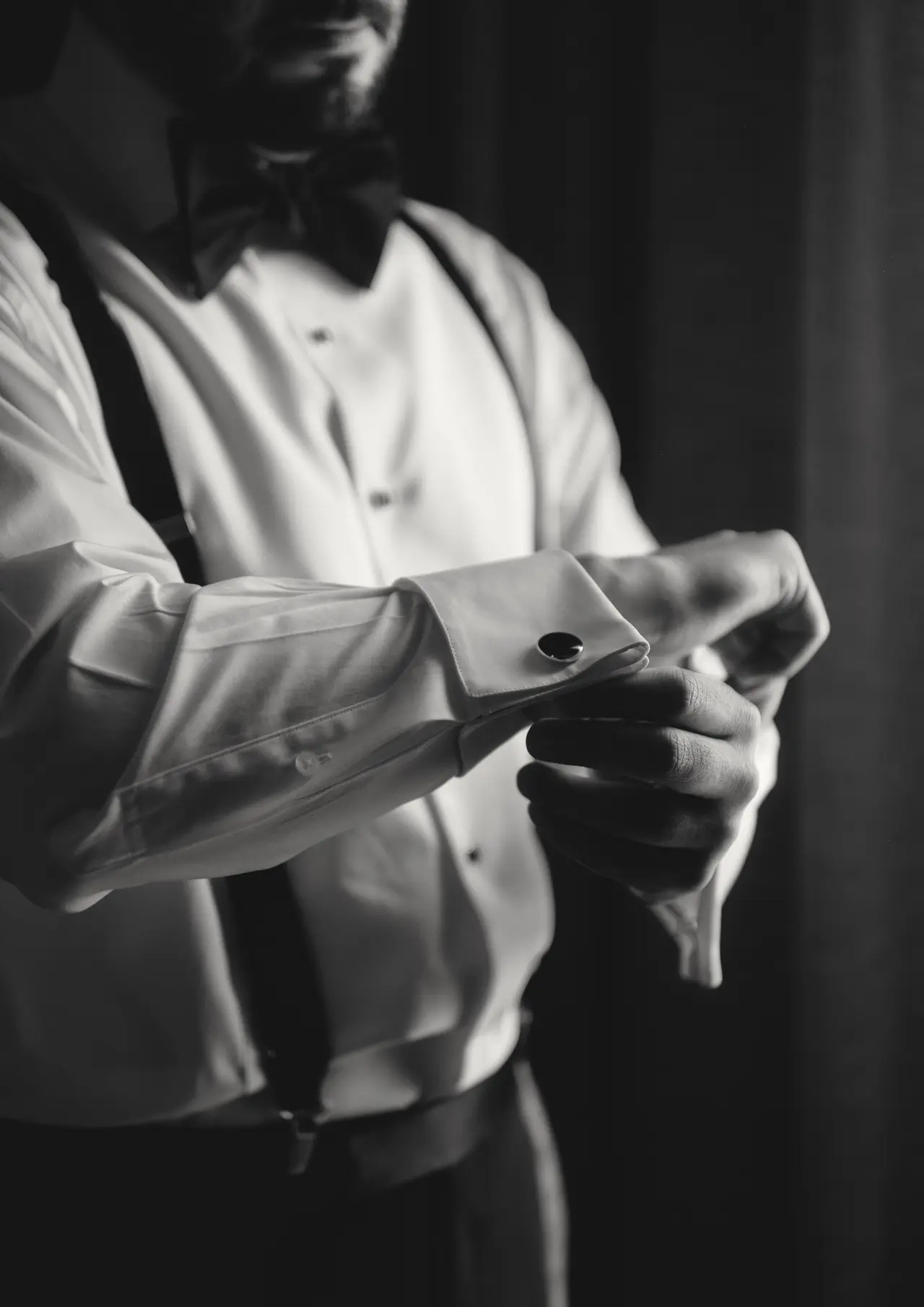 El novio se ajusta la mancuernilla del puño a contraluz, en blanco y negro