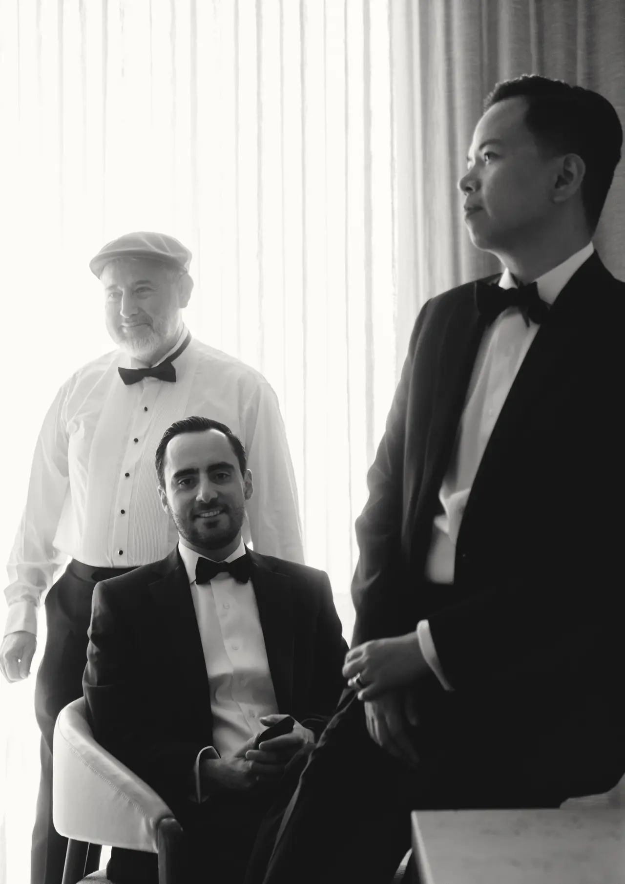 El novio con su padre y un amigo, los tres de esmoquin, en blanco y negro