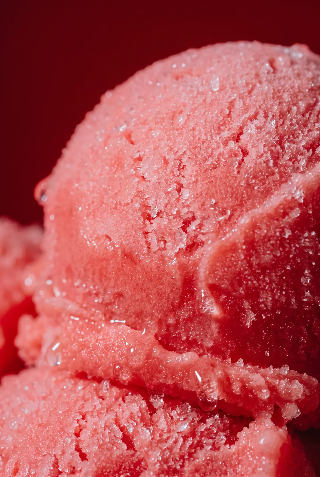Macro de una bola de nieve de fresa, el grano del hielo a contraluz