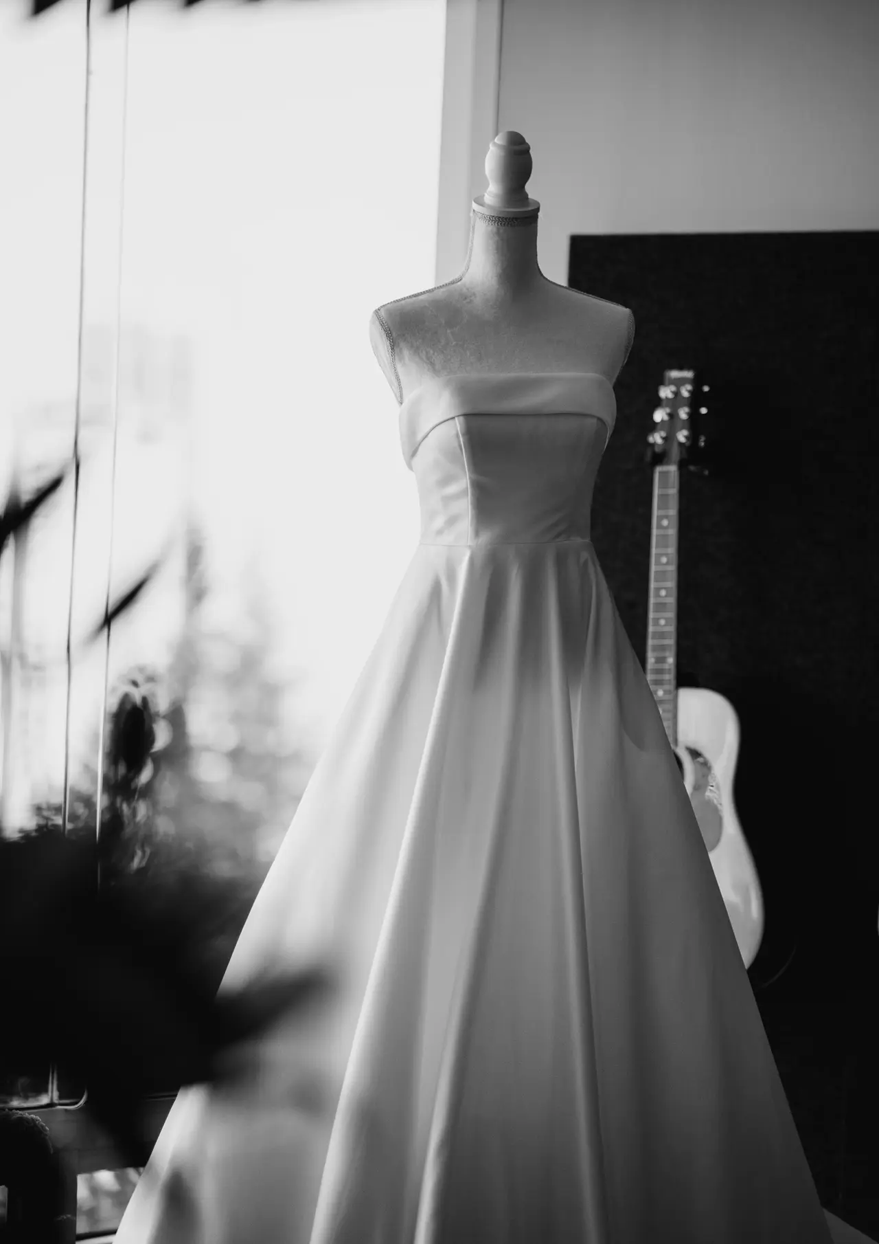 El vestido de novia colgado sobre un maniquí en una habitación en penumbra