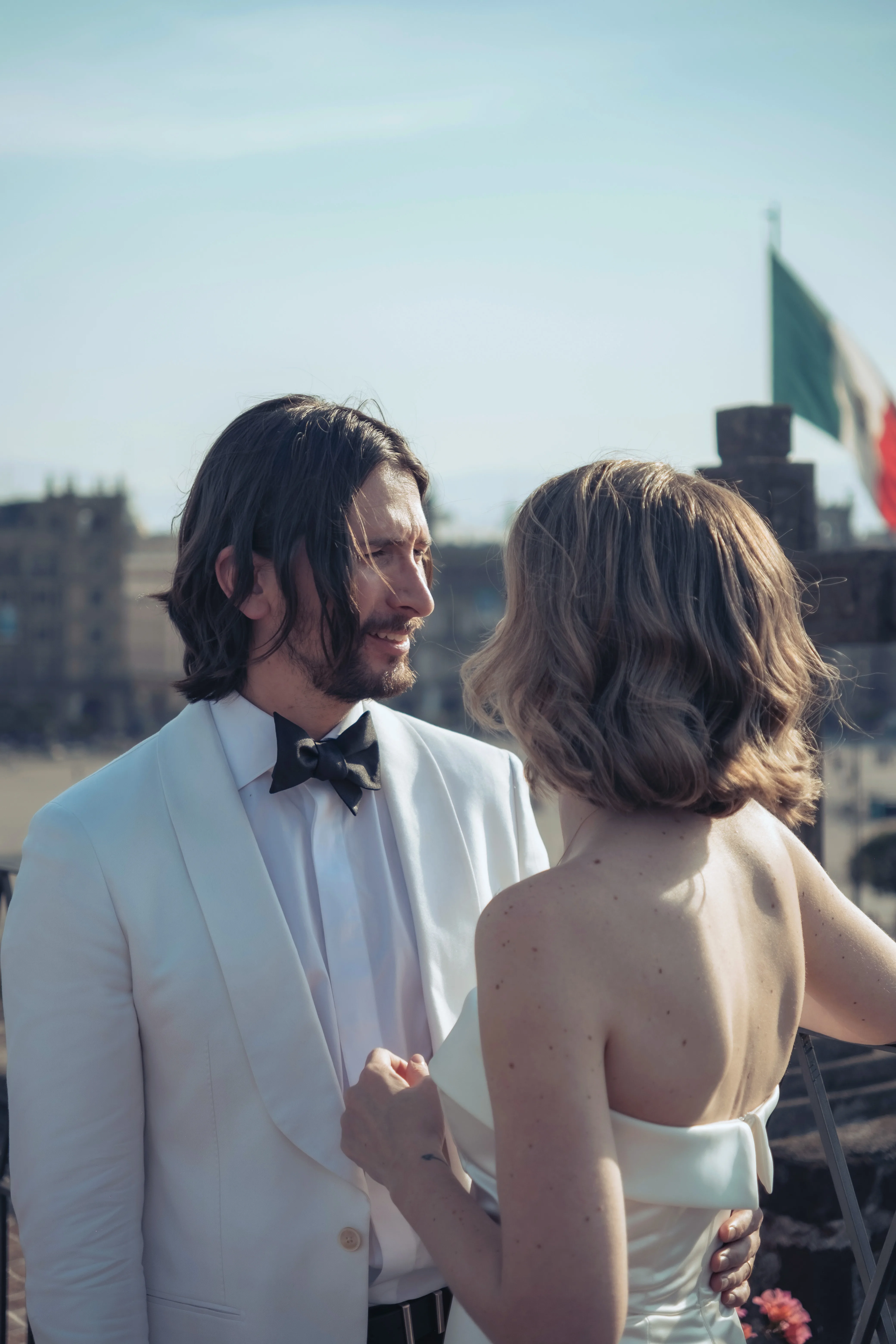 Los novios frente a frente en una azotea, con el Zócalo detrás